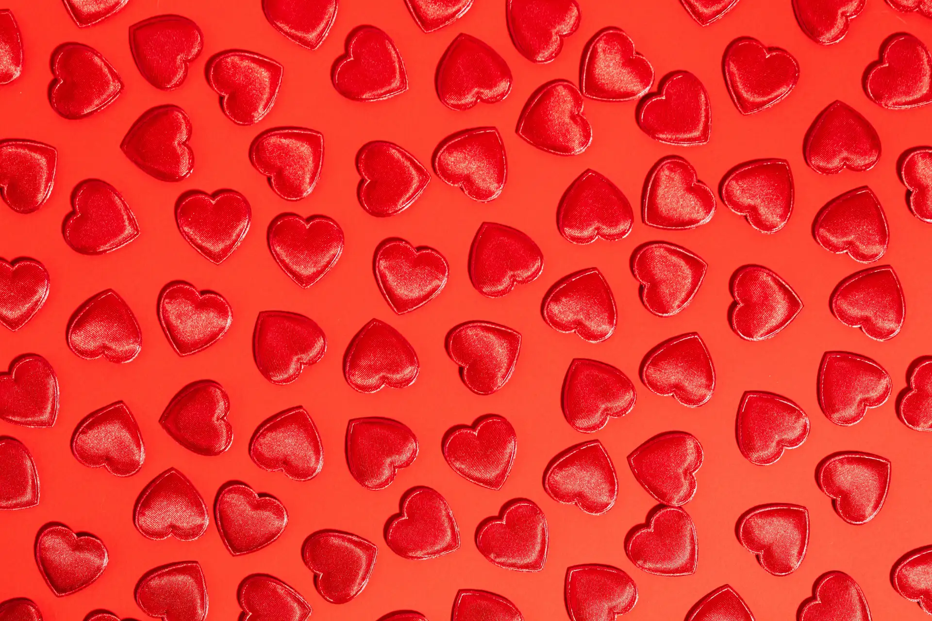 Red hearts on a red background